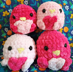 Four lovebirds in light pink, pink, and dark pink: all holding hearts.